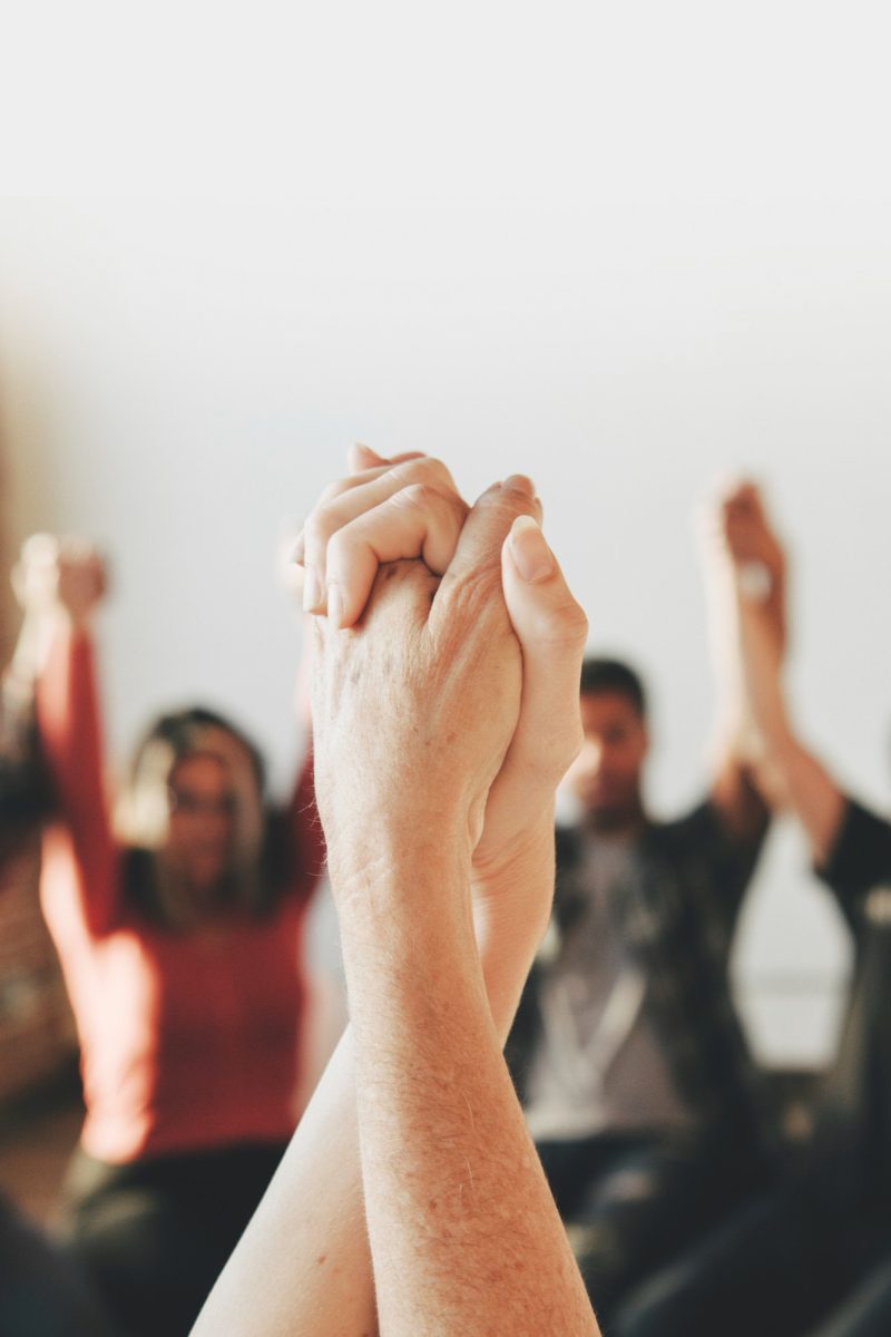 grupo-diversas-personas-sosteniendo-manos-aire